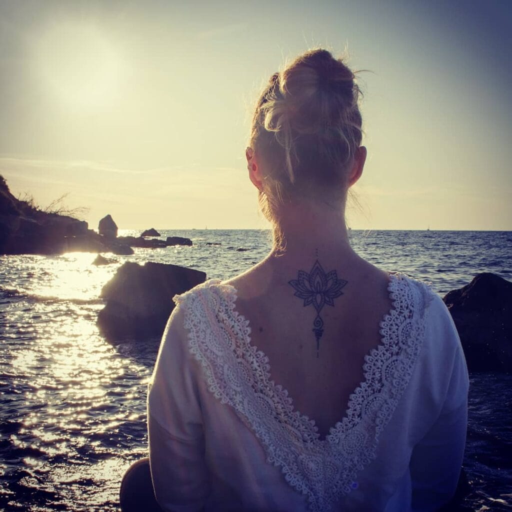 Anika, RTT terapevtka, sedi ob obali in razmišlja – simbol notranjega miru in osebne rasti.